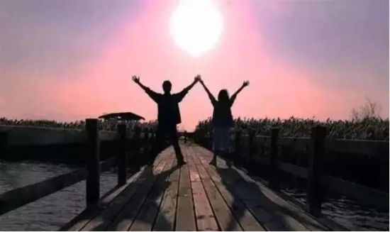 阳光下,操场旁边,一群青少年在奔跑